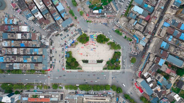 Aerial view of a bustling city square in Jiujiang, China showcasing urban life and architecture.