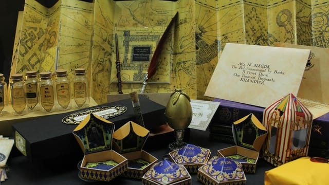 A collection of magical-themed collectibles, including maps and envelopes, inspired by famous wizardry tales.