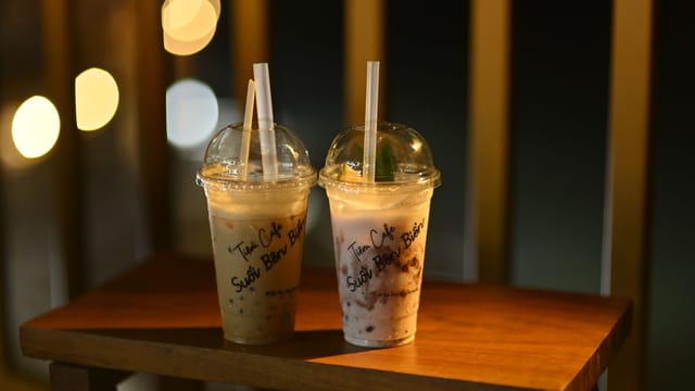 Coffee drinks on a wooden table at night in Vũng Tàu, Vietnam.