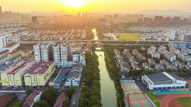 Stunning aerial cityscape of Suzhou, China at sunset with vibrant skyline and waterway.