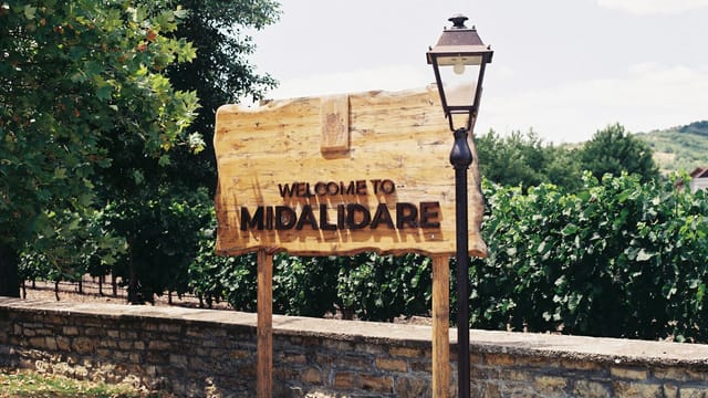 Welcome sign at Midalidare Vineyard with lush greenery background.