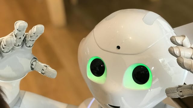 A futuristic humanoid robot with glowing green eyes in a modern setting.