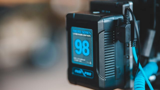 Close-up of a high-capacity portable battery with digital display showing 98 percent charge.