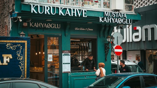 Street view of a traditional coffee shop with people in Kayseri, Türkiye.