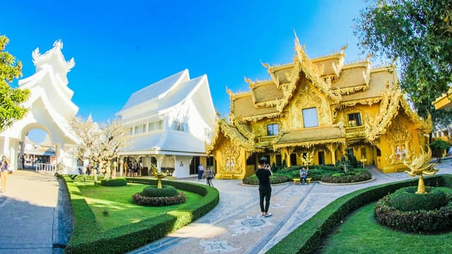 Majestic golden and white temples contrast amid lush gardens showcasing traditional Thai architecture.