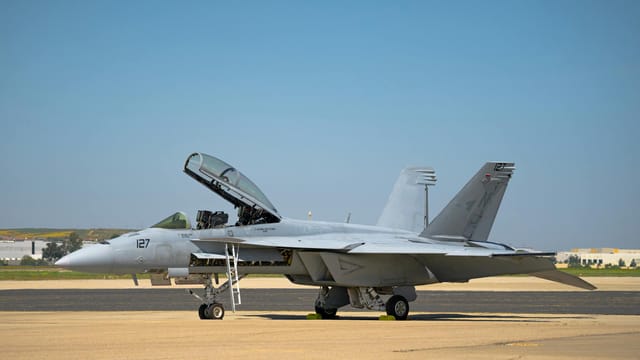 Military F/A-18 Super Hornet aircraft stationed on a tarmac at March Air Reserve Base under clear skies.