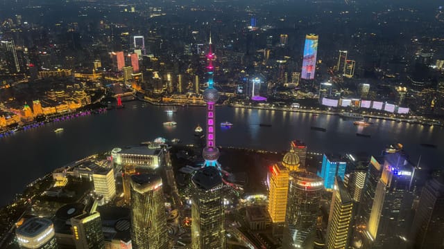 Dazzling night view of the illuminated Shanghai skyline featuring the iconic Oriental Pearl Tower.
