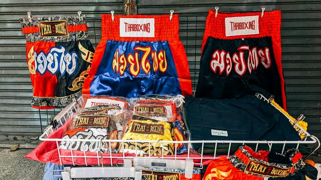 Vibrant Thai boxing shorts on display in Bangkok market, showcasing local culture.