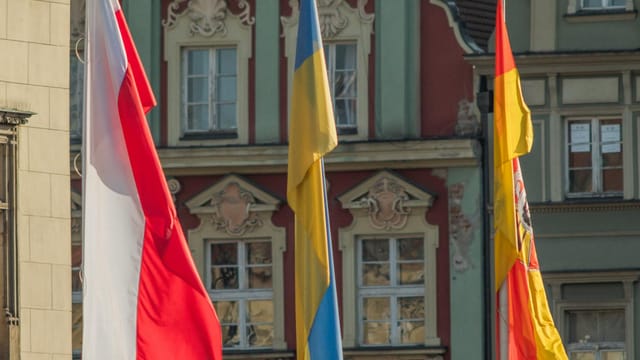 Flags of Poland, Ukraine, and Spain displayed in Wrocław's city center.