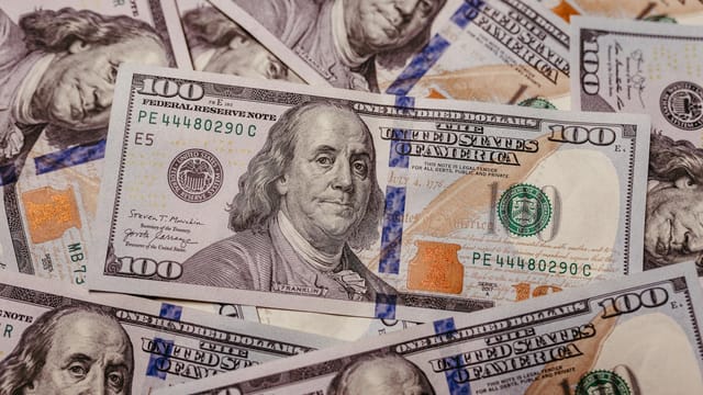 Stack of 100 dollar US banknotes with Benjamin Franklin portrait.