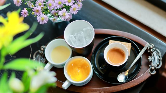An elegant tray with various beverages and a bouquet of flowers offers a refreshing and inviting atmosphere.