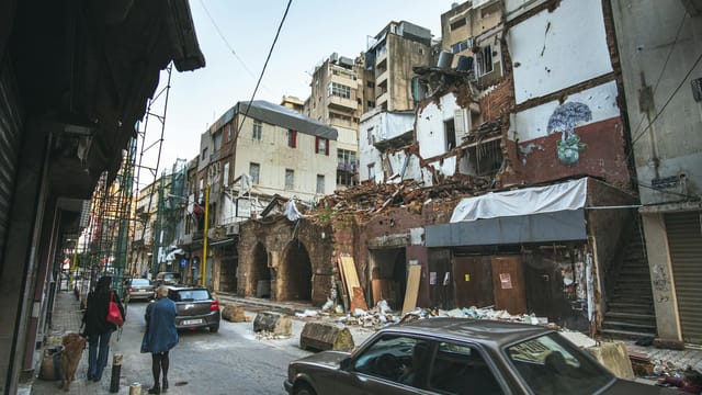 Street scene in Beirut depicting building damage and recovery efforts after the port explosion.