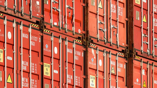 Close-up of stacked red shipping containers used for logistics and global trade.