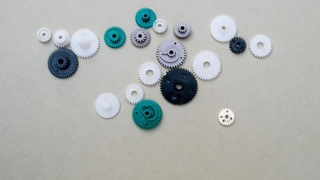 A collection of colorful plastic gears arranged on a plain surface, ideal for mechanical or DIY concepts.