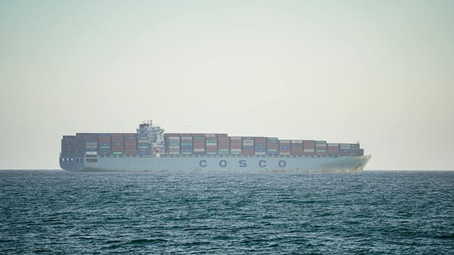 A cargo ship transporting containers across the Pacific Ocean near Long Beach, California.