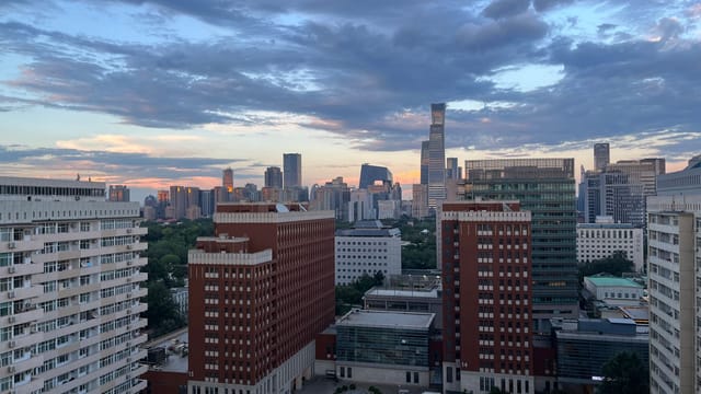 A stunning evening view of Beijing's skyline featuring modern skyscrapers and vibrant sunset colors.
