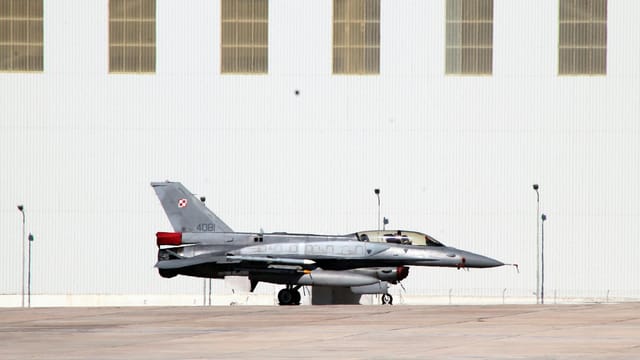 A Polish Air Force F-16 fighter jet parked outside a hangar in Luqa, Malta.