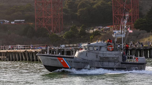 US Coast Guard boat patrolling with Golden Gate Bridge background.