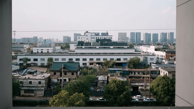 Captured through a window, this urban landscape reveals both old and modern architecture under daylight.