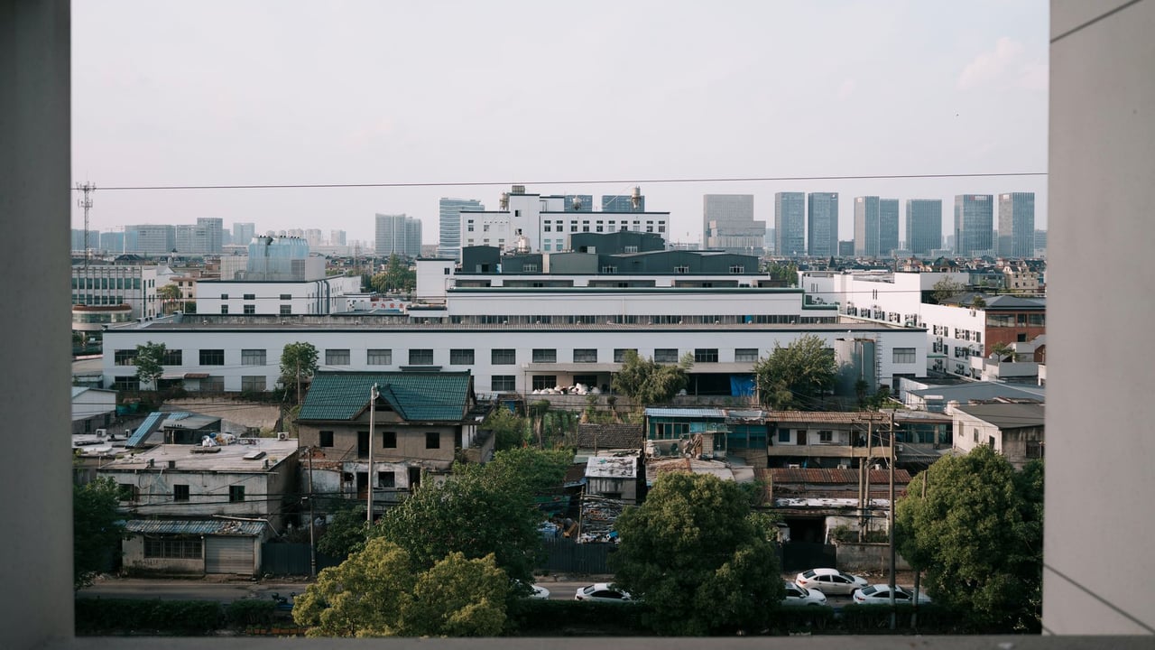 Captured through a window, this urban landscape reveals both old and modern architecture under daylight.