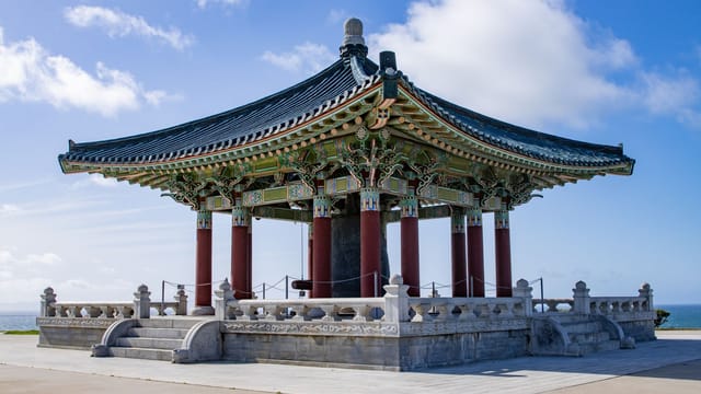 The Korean Friendship Bell pavilion under a clear blue sky in San Pedro, California.