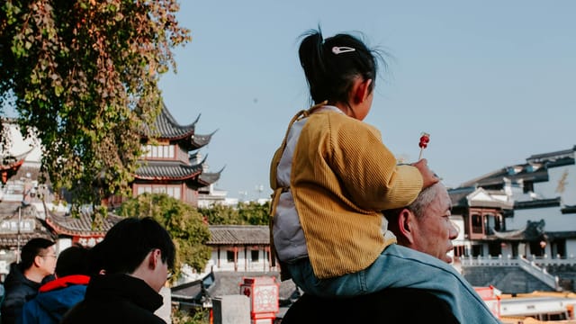 Capturing family moments in Nanjing, China during a vibrant autumn afternoon.